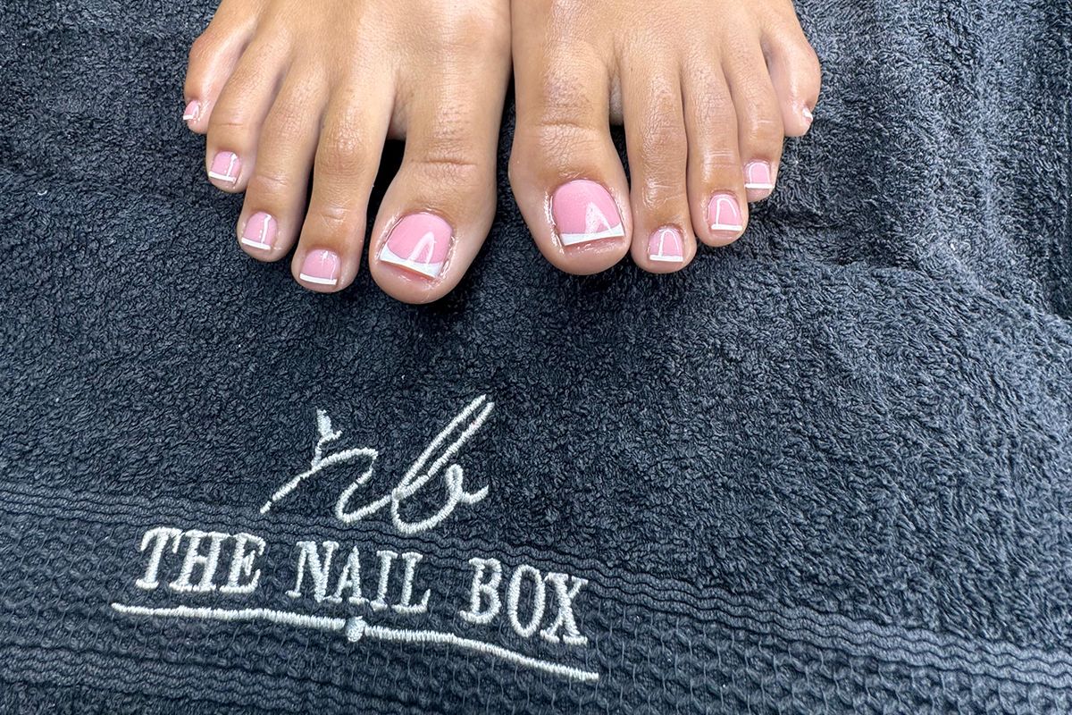Finished pedicure on a branded The Nail Box towel