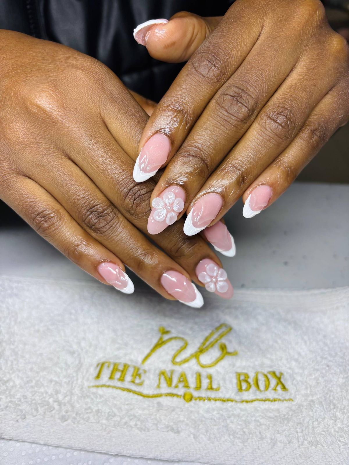 Finished nail set resting on a branded The Nail Box towel