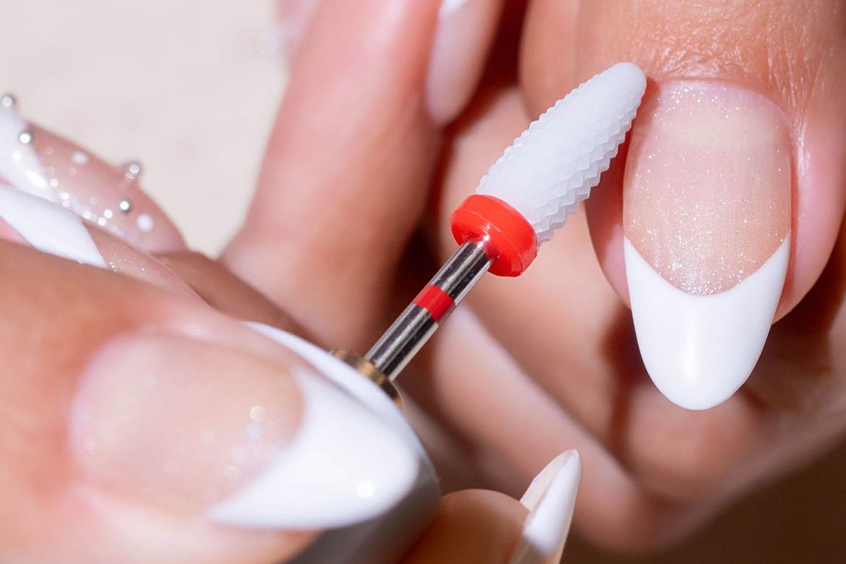 Electric file refining a french-tip nail during training